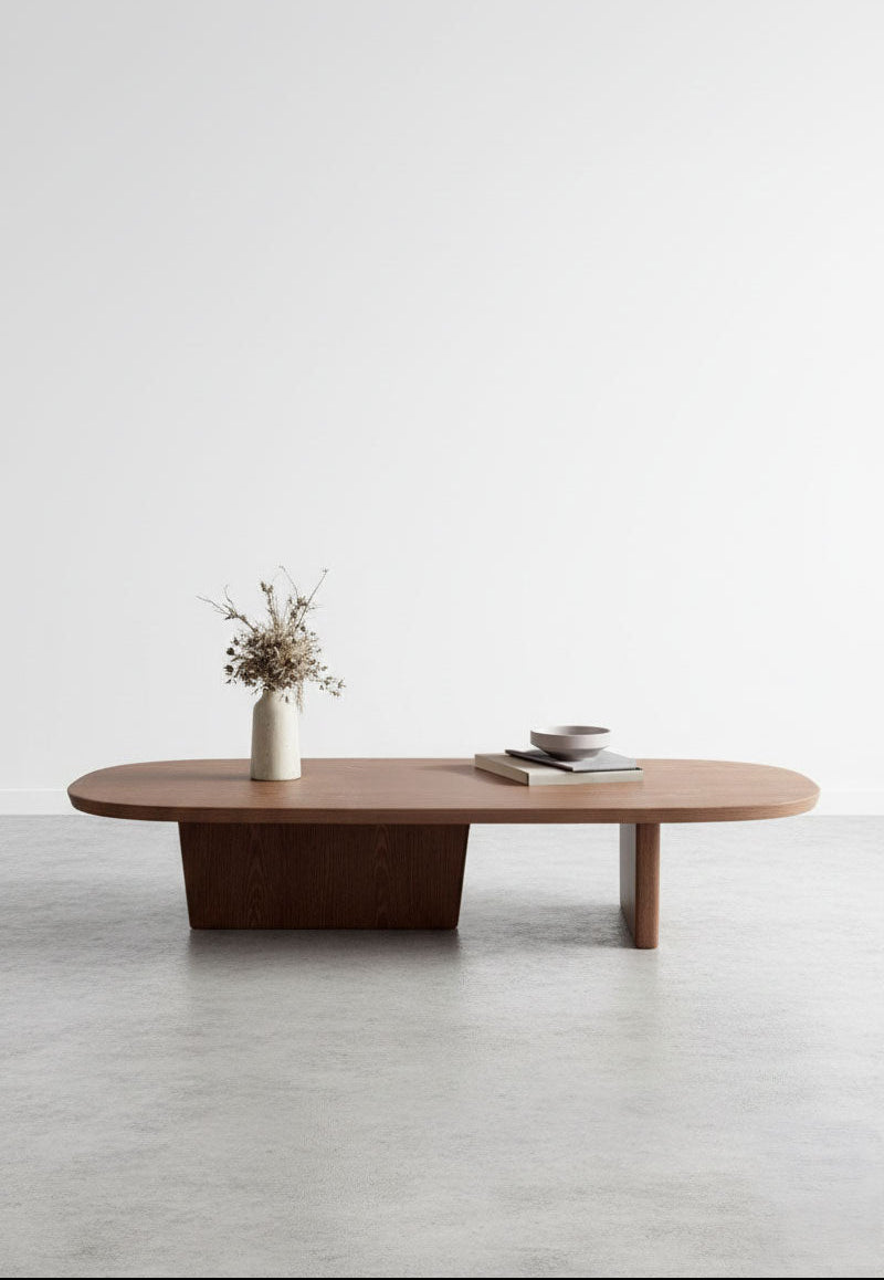 Wooden coffee table with a vase and books on a light gray floor and white wall