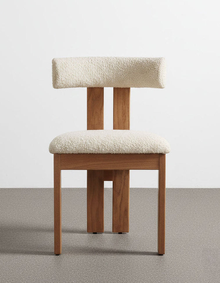 Wooden chair with white cushioned seat and backrest on a plain background